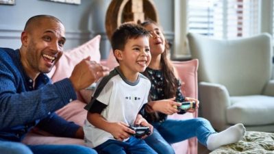 kids playing gamestop with their dad cheering them on