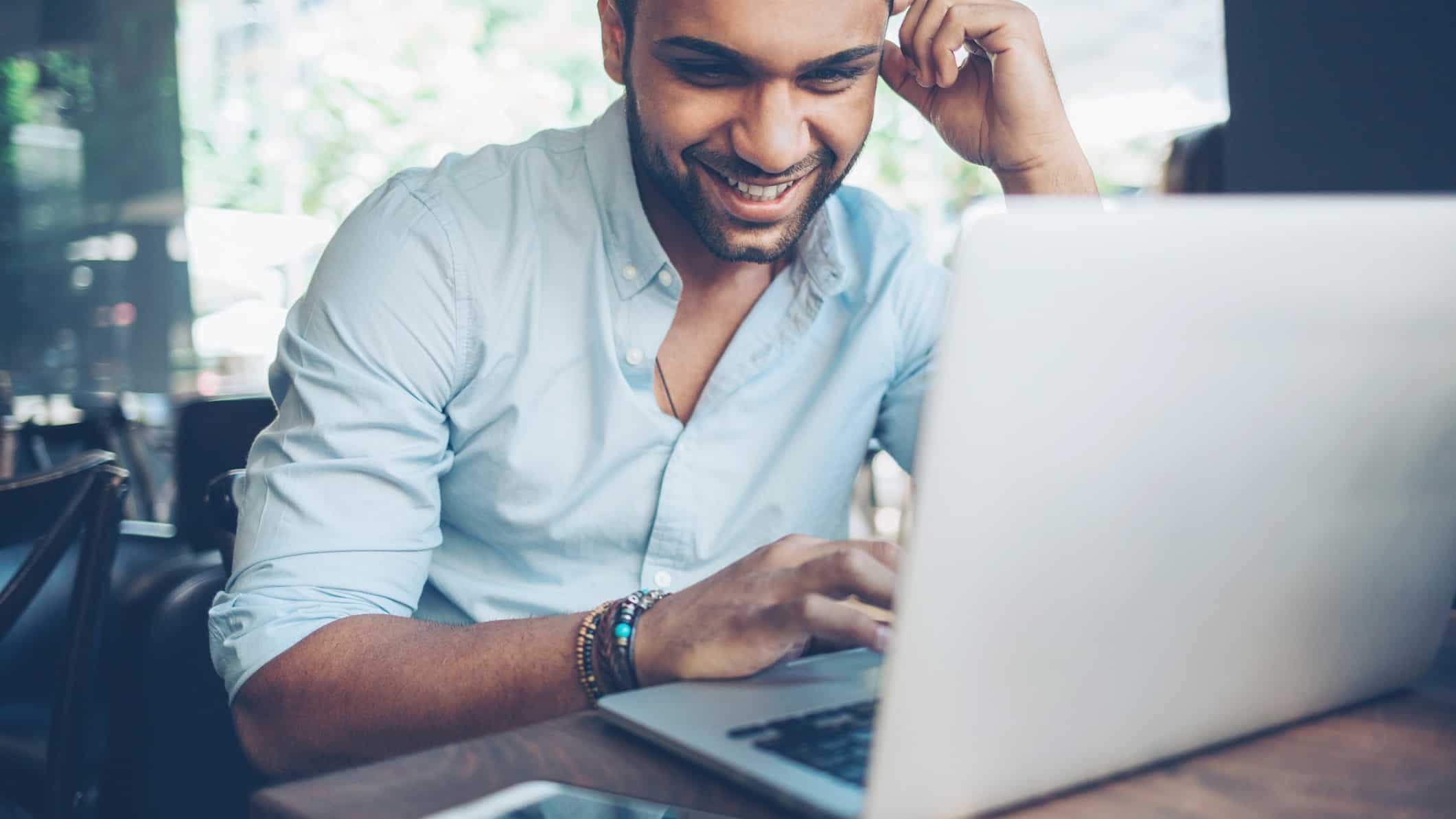 man using laptop happy at rising share price
