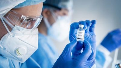 health professionals looking at a veil of moderna vaccine