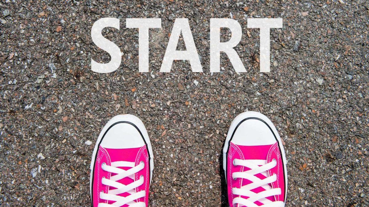 Two red sneakers on the start line, indicating a new investor learning about share price movement and how to invest