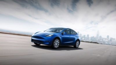 blue Tesla y electric vehicle on a road