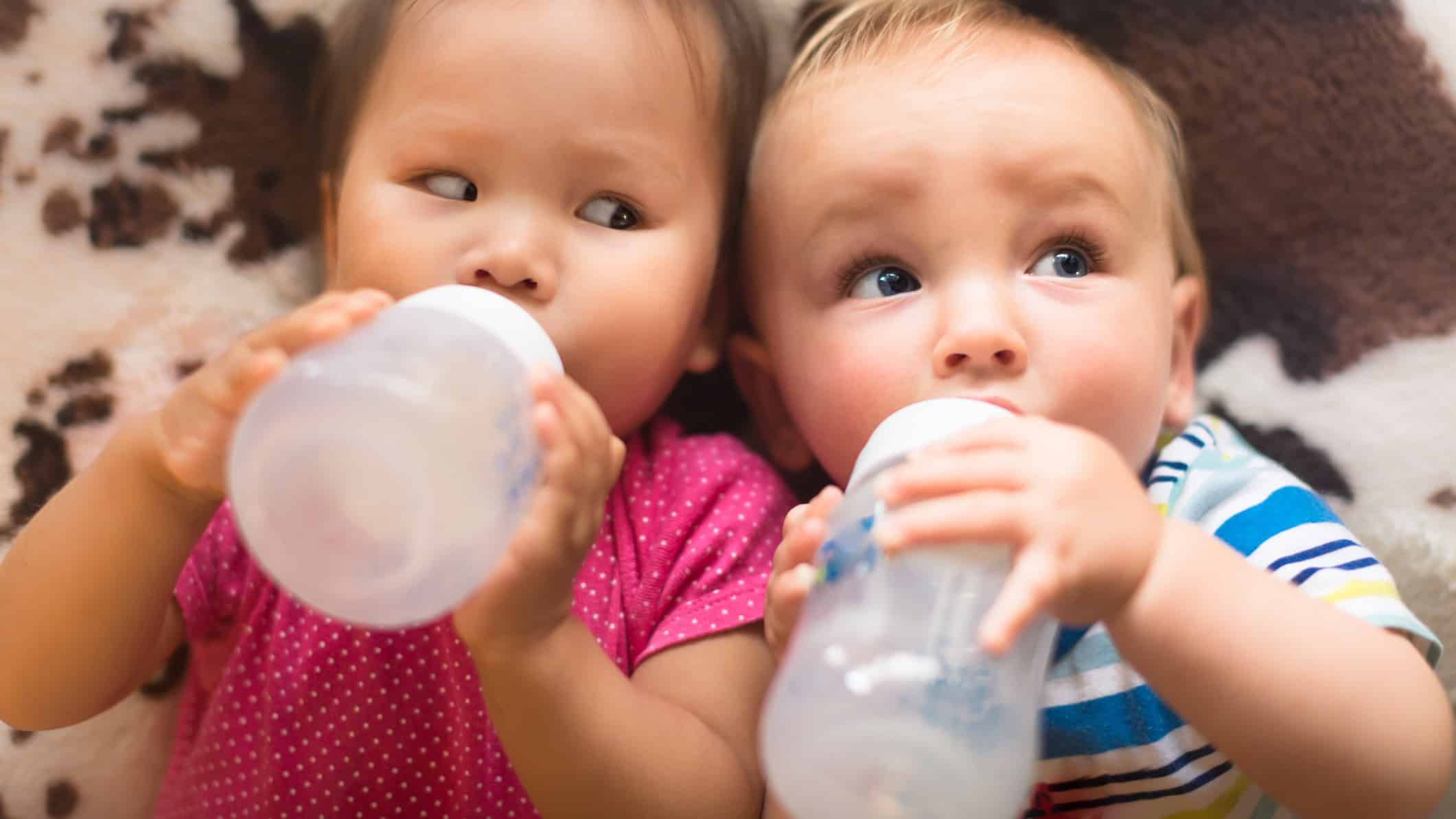 Babies drinking from milk bottles