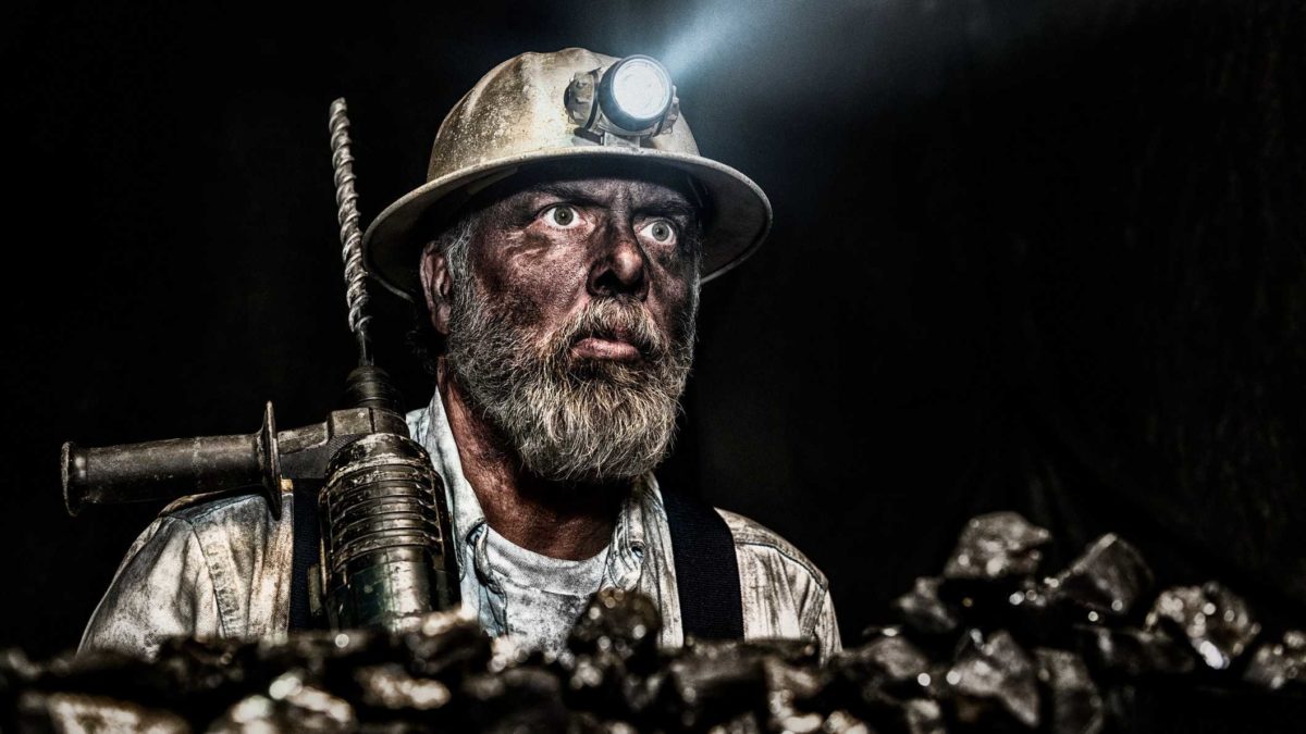 Coal miner with dirty face in a mine
