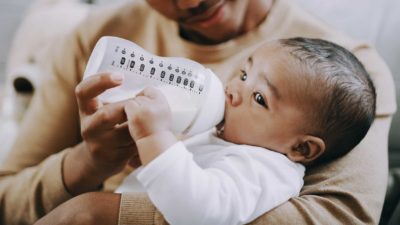 Dad feeding baby from milk bottle