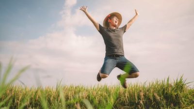 Elders share price Farmer jumping for joy in field