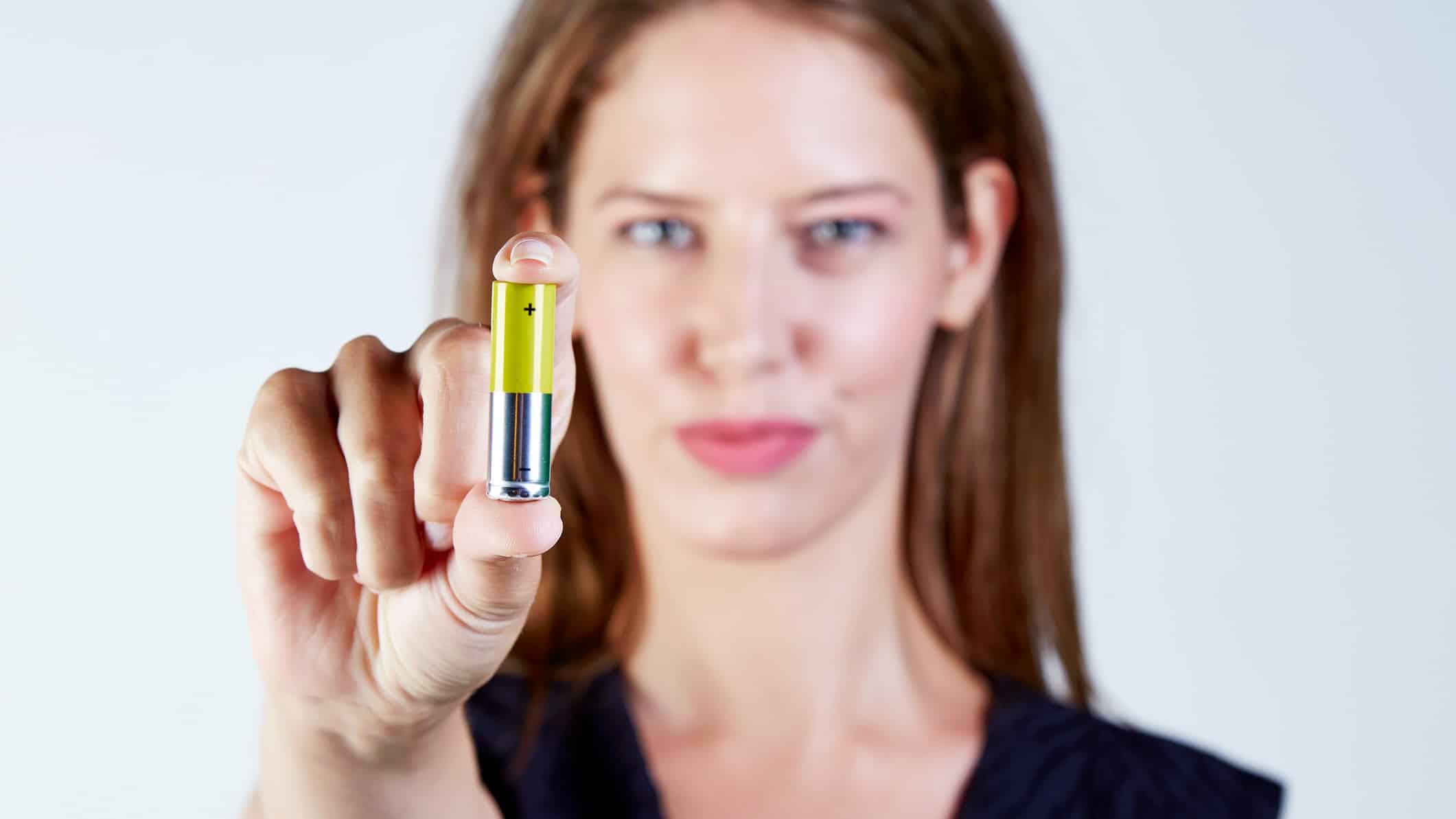 green lithium battery being held by person
