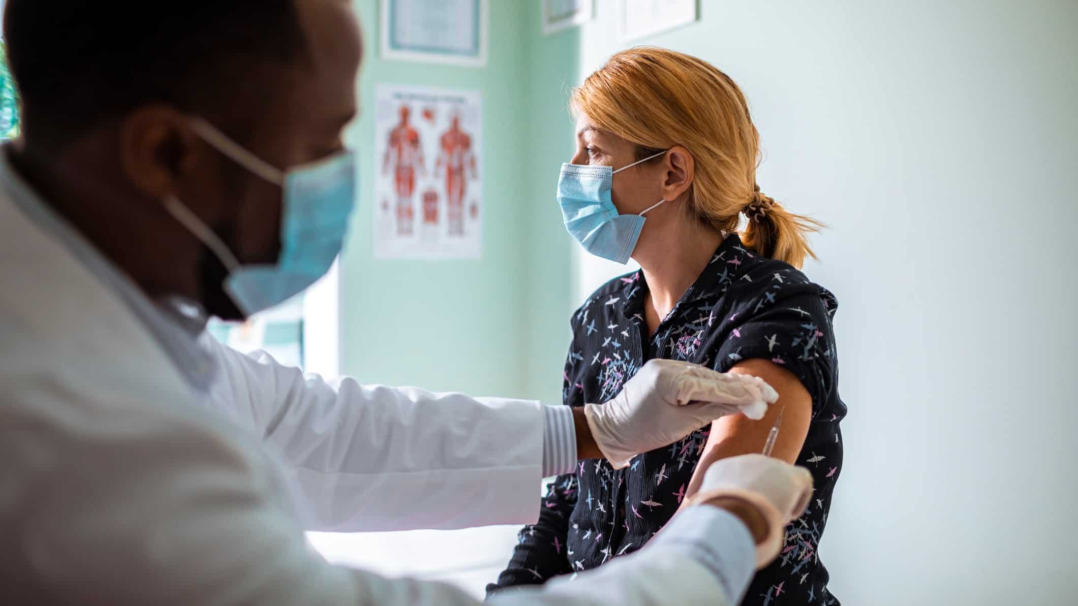 person receiving vaccination from a medical worker