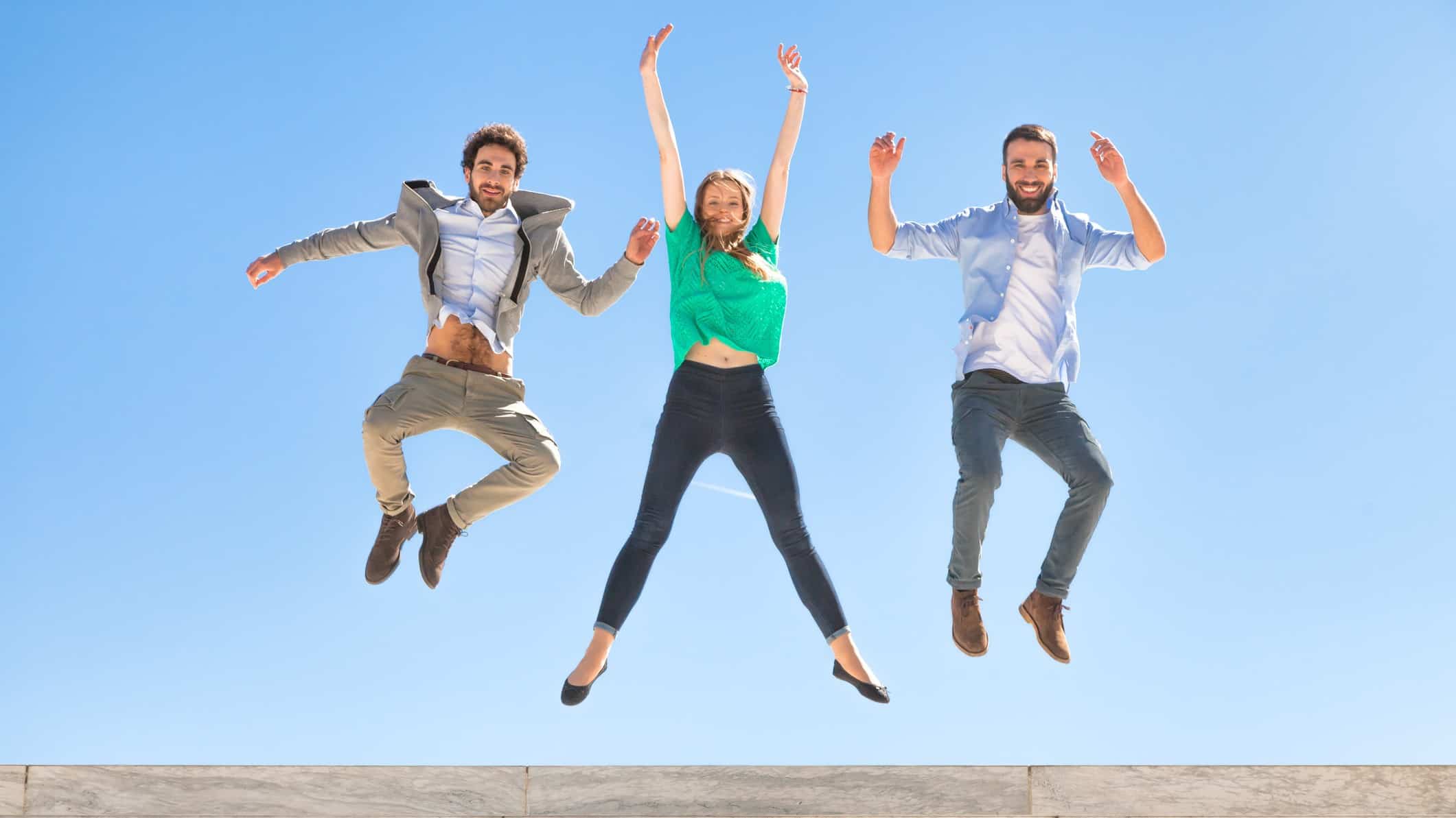 people leaping in celebration against a blue sky