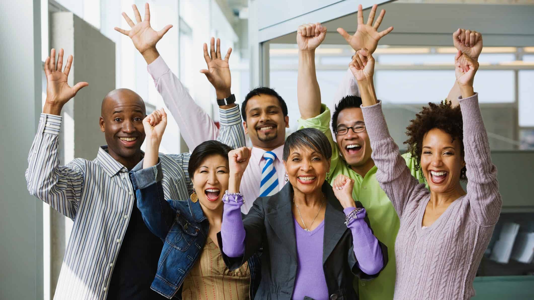 people celebrating with arms raised and happy faces