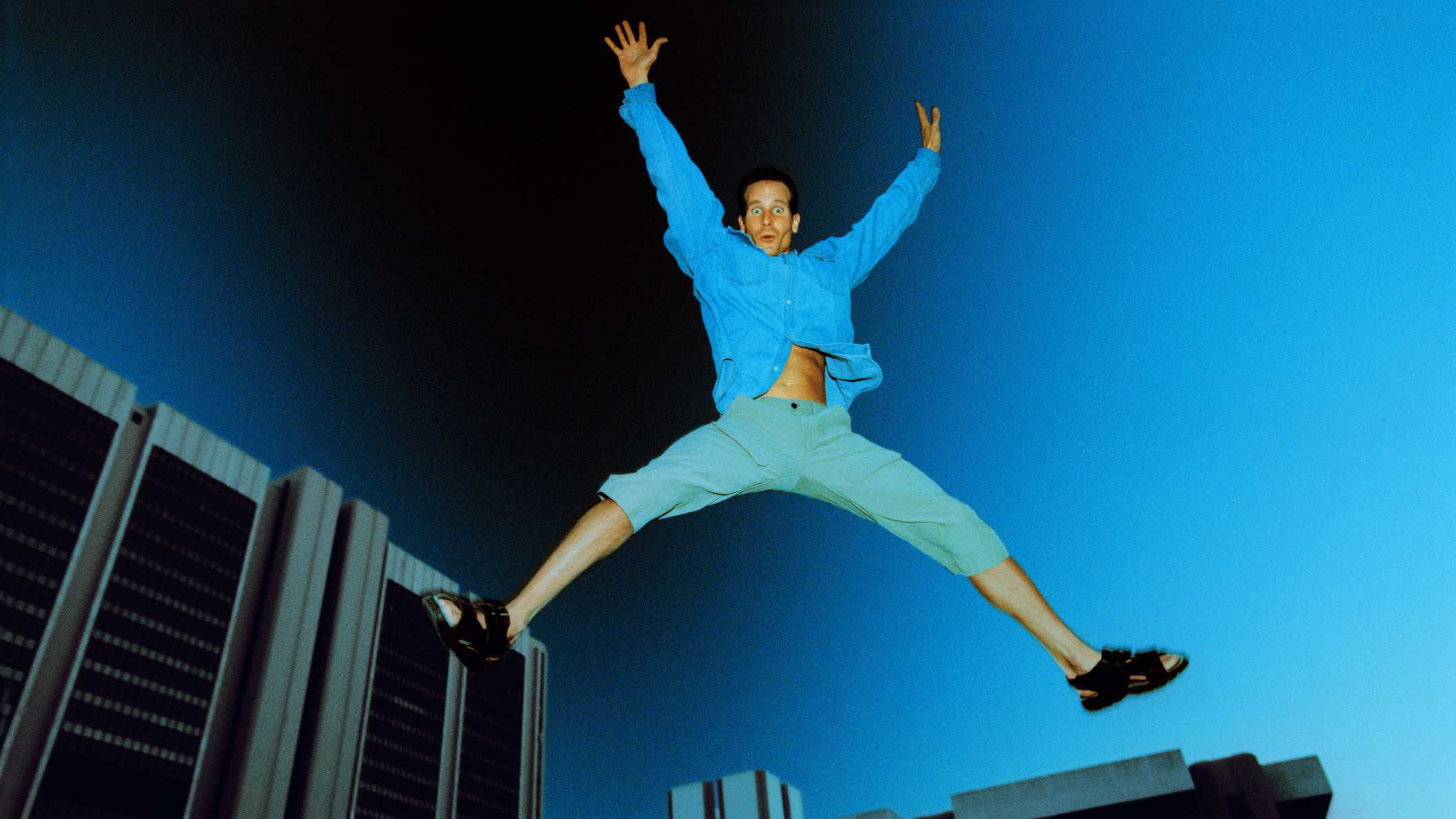 active person star jumping amid city landscape