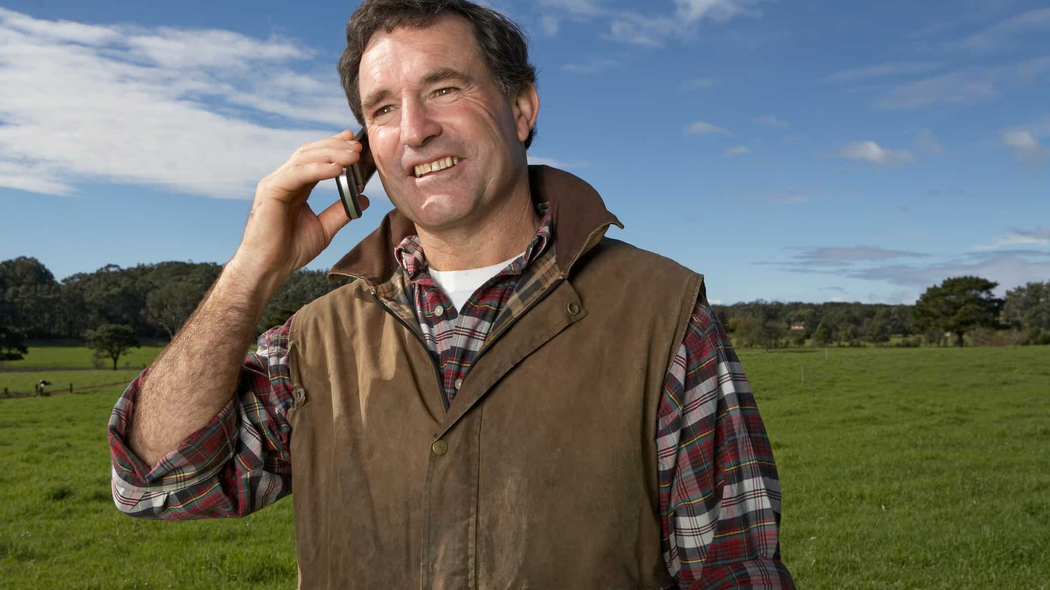 farmer on telephone enjoying telecommunications in rural area