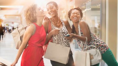 Three happy women shopping with shopping bags at mall