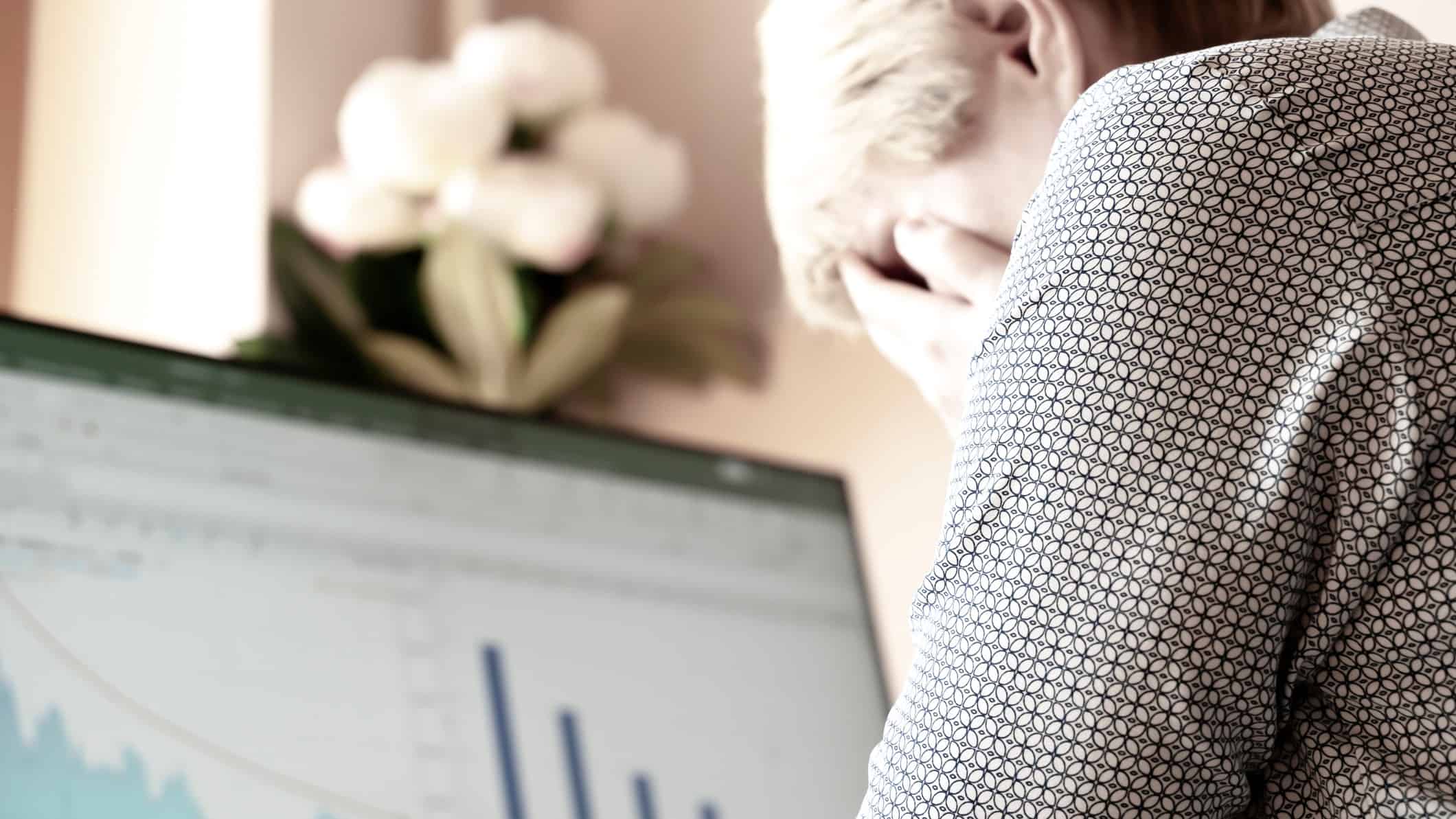 Investor with her head in hands in front of laptop depicting falling asx share price.