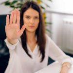woman sitting at desk holding hand up in stop motion