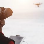 A man flying a drone using a remote controller