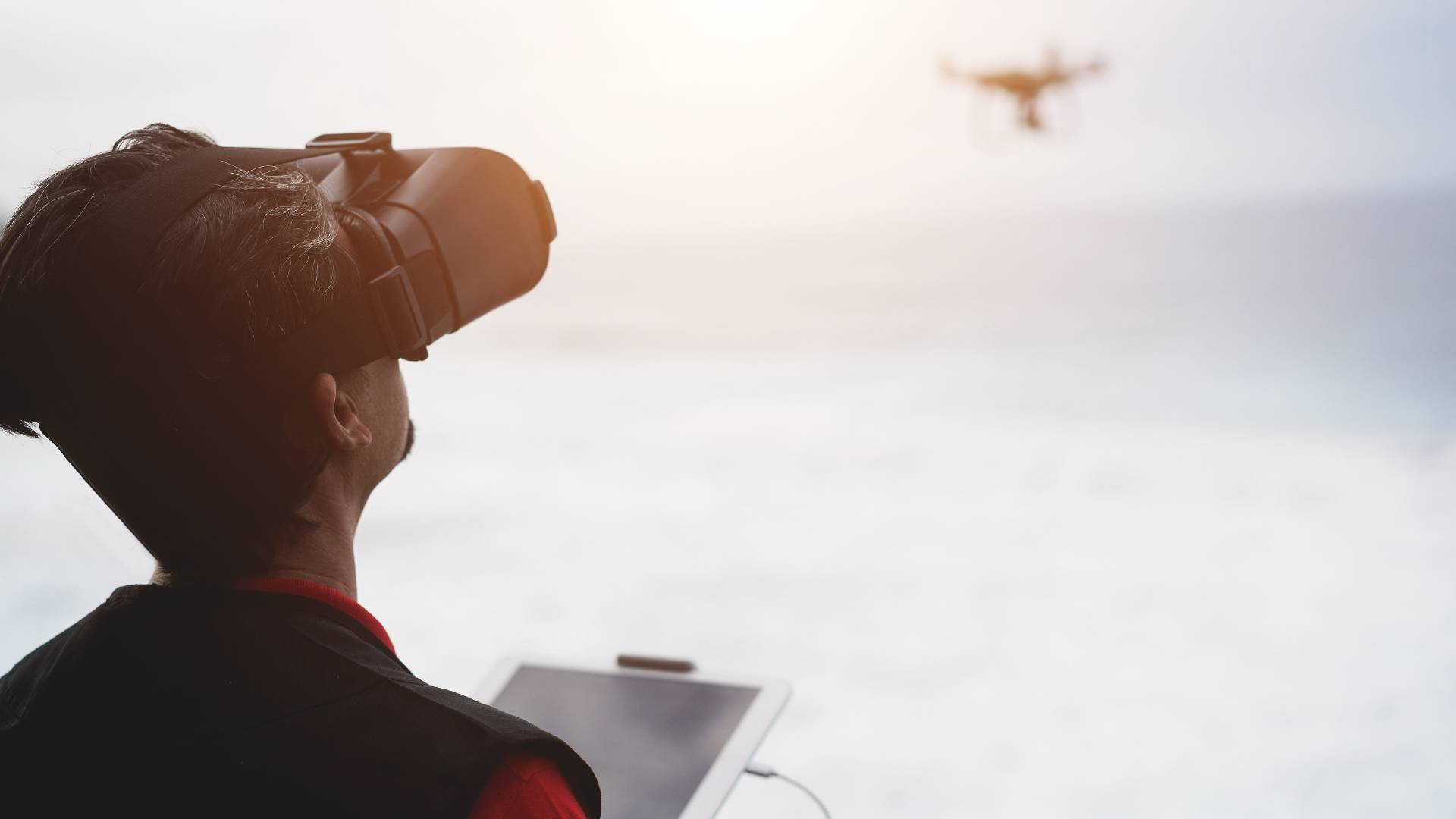 A man flying a drone using a remote controller