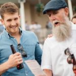 Two men at the races looking at ticket after having placed a bet