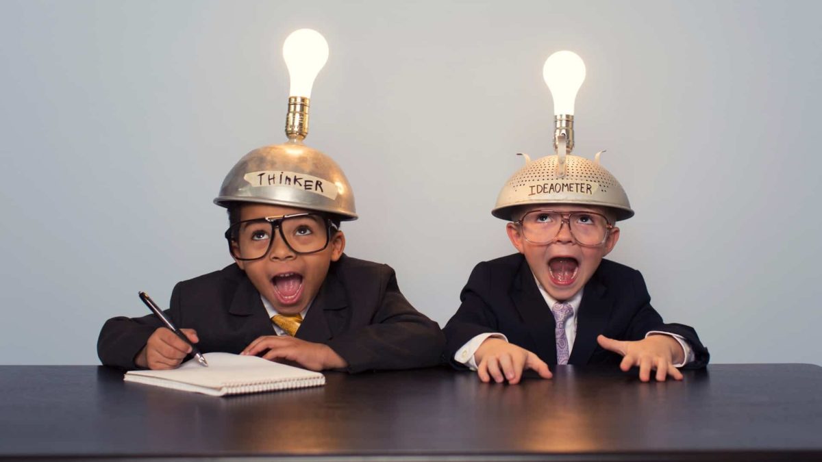 Two young boys sit at a desk wearing helmets with lightbulbs, indicating two ASX 200 shares that a broker has recommended as buys today