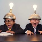 Two young boys sit at a desk wearing helmets with lightbulbs, indicating two ASX 200 shares that a broker has recommended as buys today