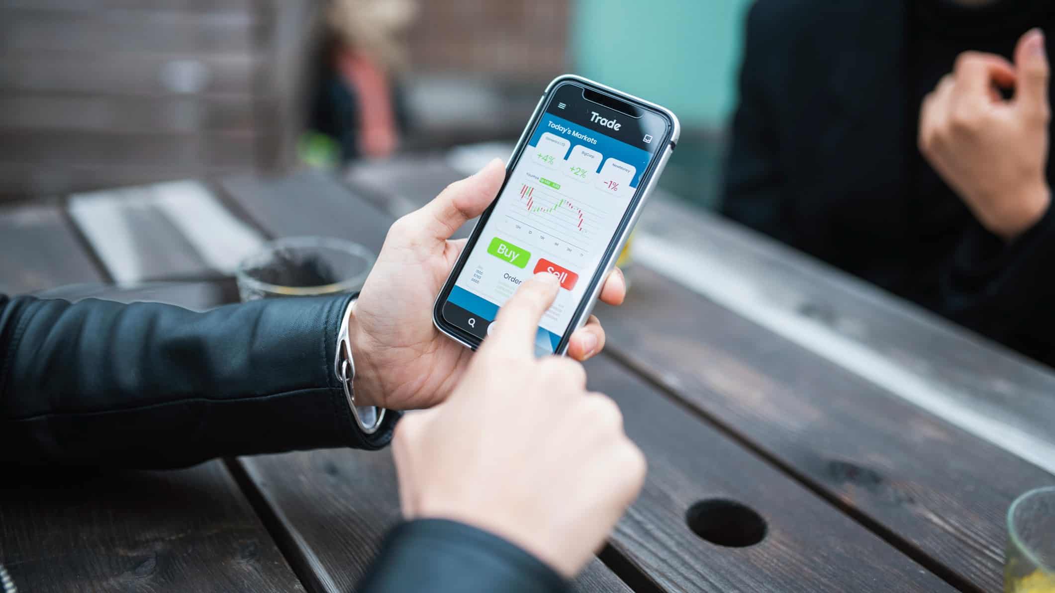 Person choosing to buy or sell on their mobile phone