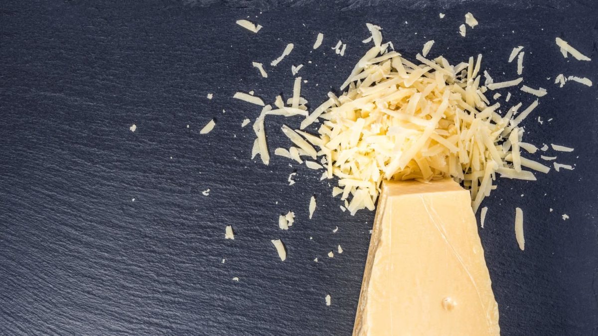 A block of cheese with grated explosion on top