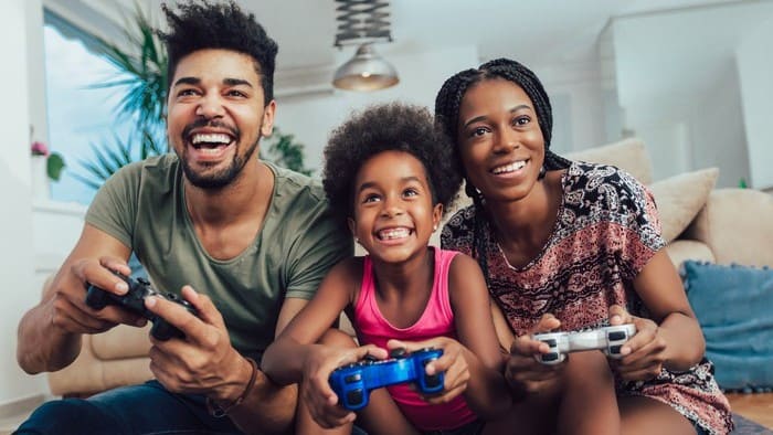 A happy family playing video games smiles and laughs together