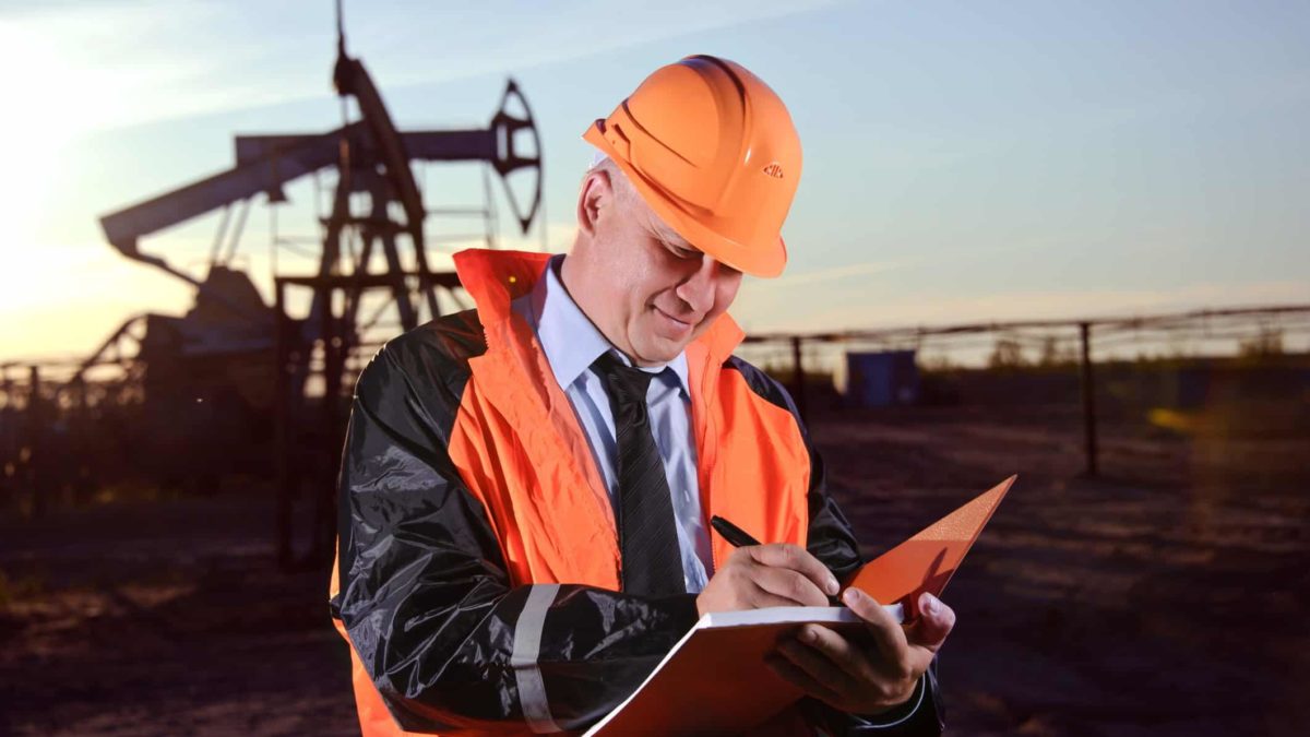 An oil worker assesses productivity at an oil rig as ASX 200 energy shares continue to rise