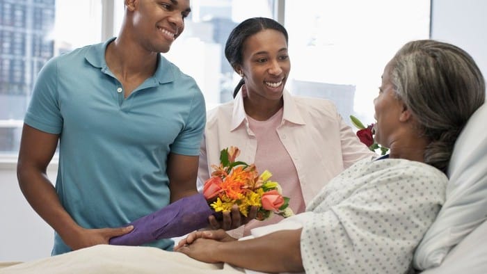 man and woman visiting a patient in hospital