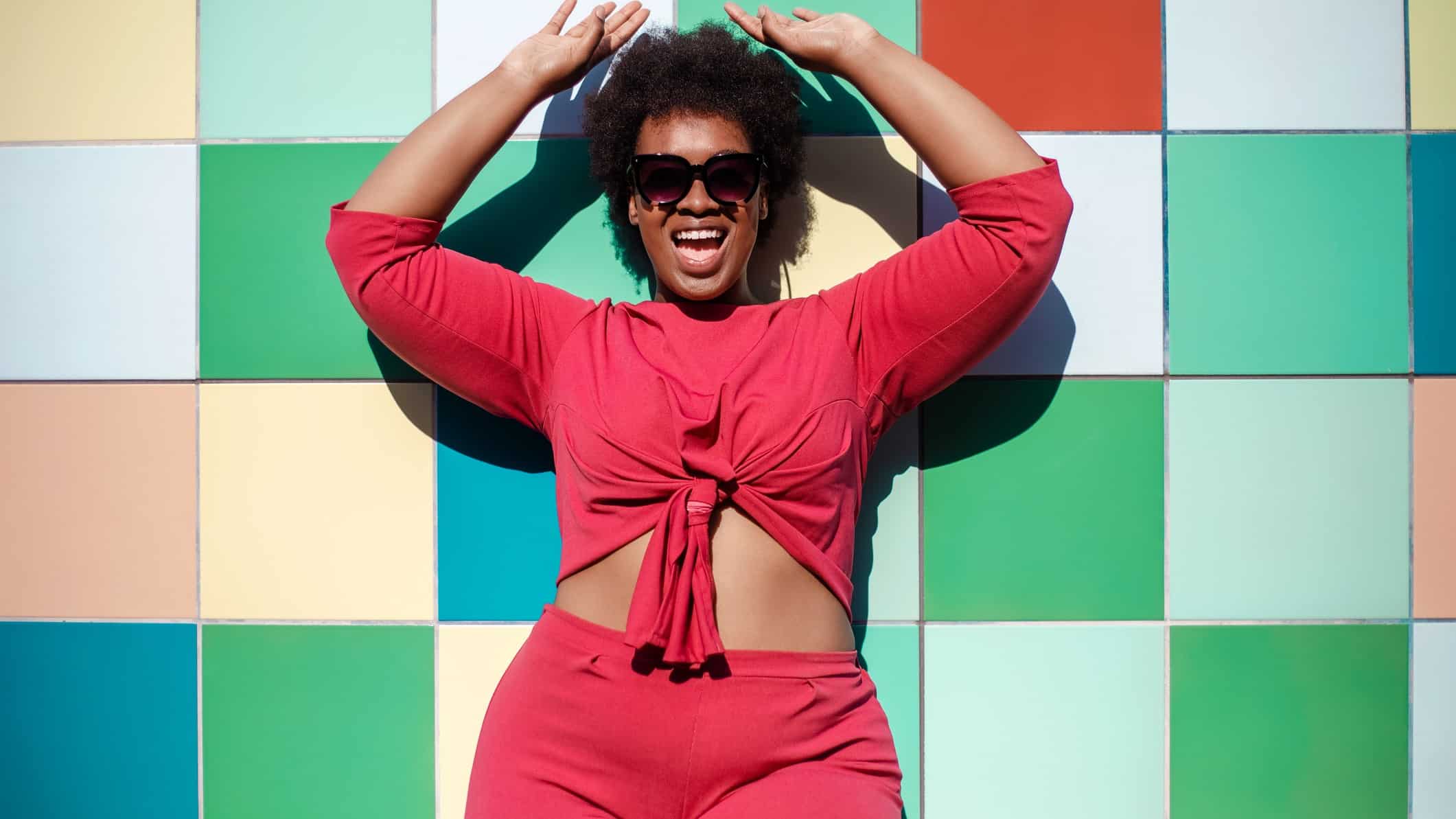 large woman with arms raised in happiness/celebration; plus size women's fashion retail