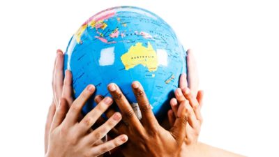 map of australia featured on a globe being held by many hands