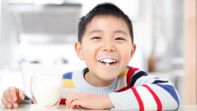 smiling child drinking milk from a glass, A2 milk share price rise, increase, up, A2 sales to china