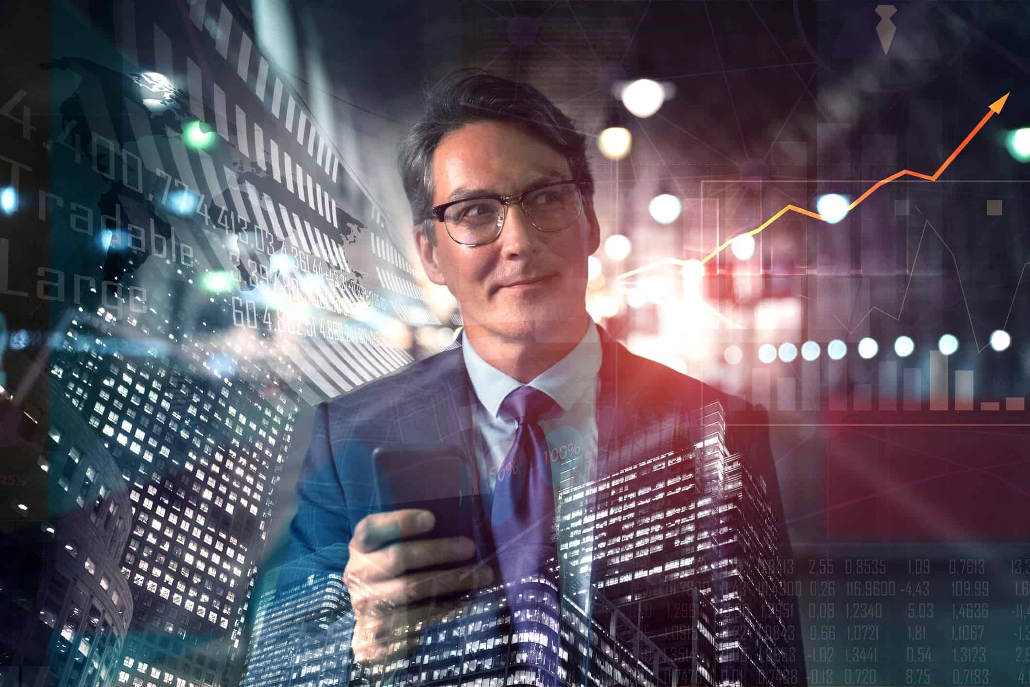 Man holding phone in front of stocks graphic