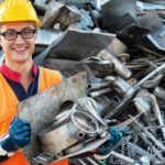 Smiling worker in metal landfill.