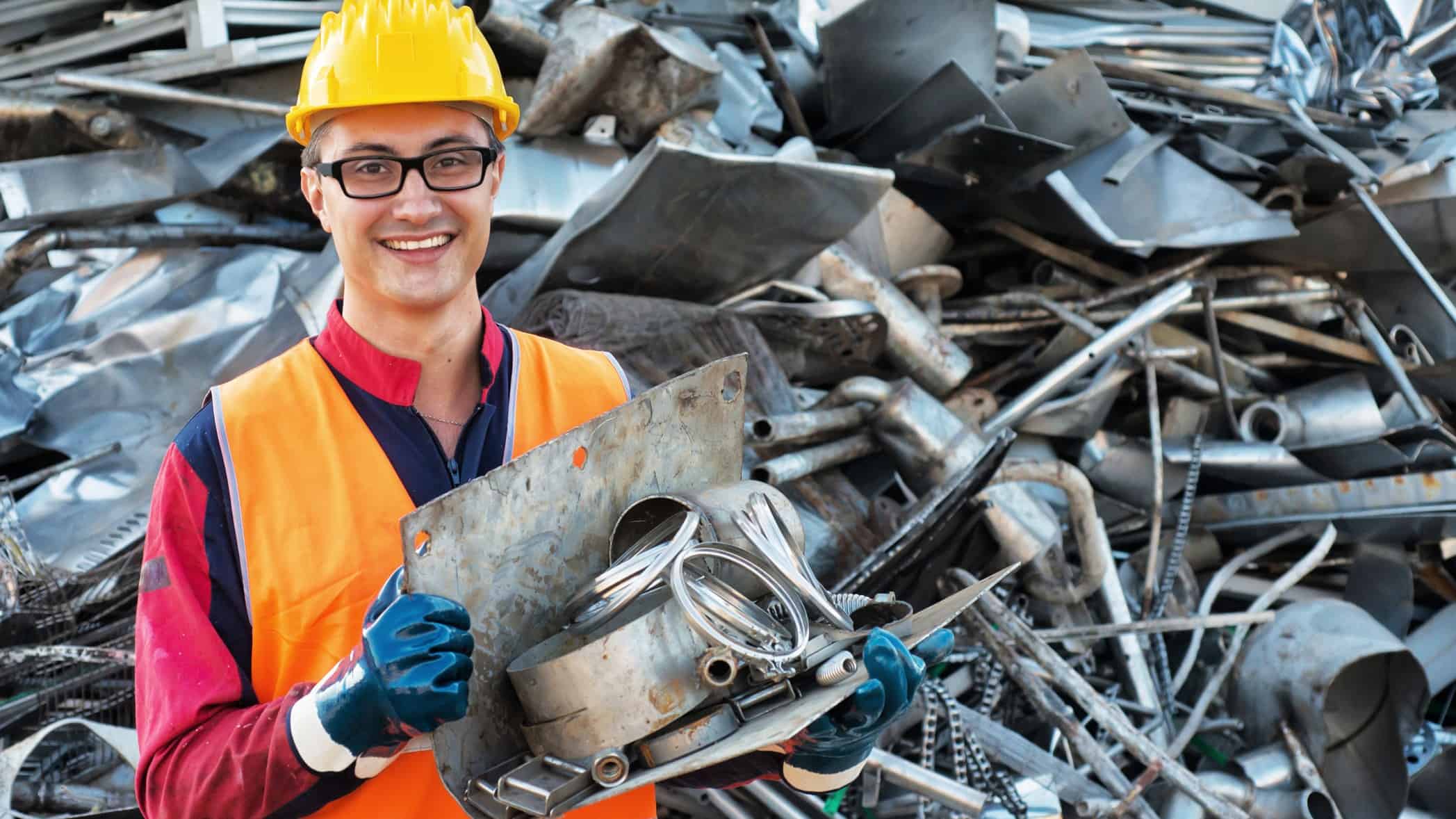Smiling worker in metal landfill.