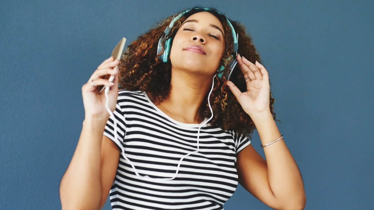 Woman listening to music through headphones