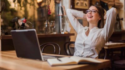 Young female AGL investor leans back in her desk chair feeling relieved after the AGL share price soared today