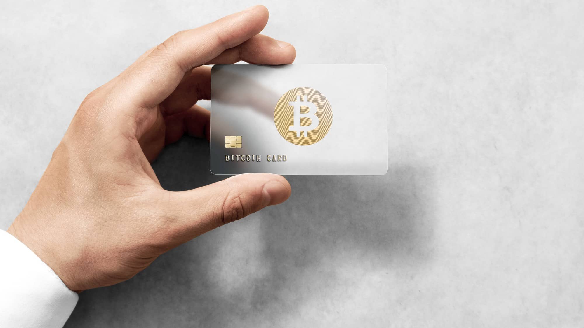 man's hand holding a credit card that says bitcoin card
