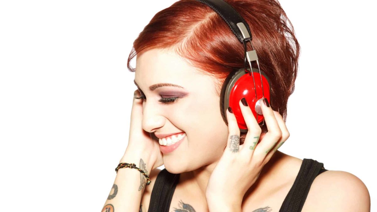 happy woman smiling as she listens to music on headphones