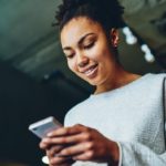 Investor looking at smartphone and considering Evolution's share purchase plan