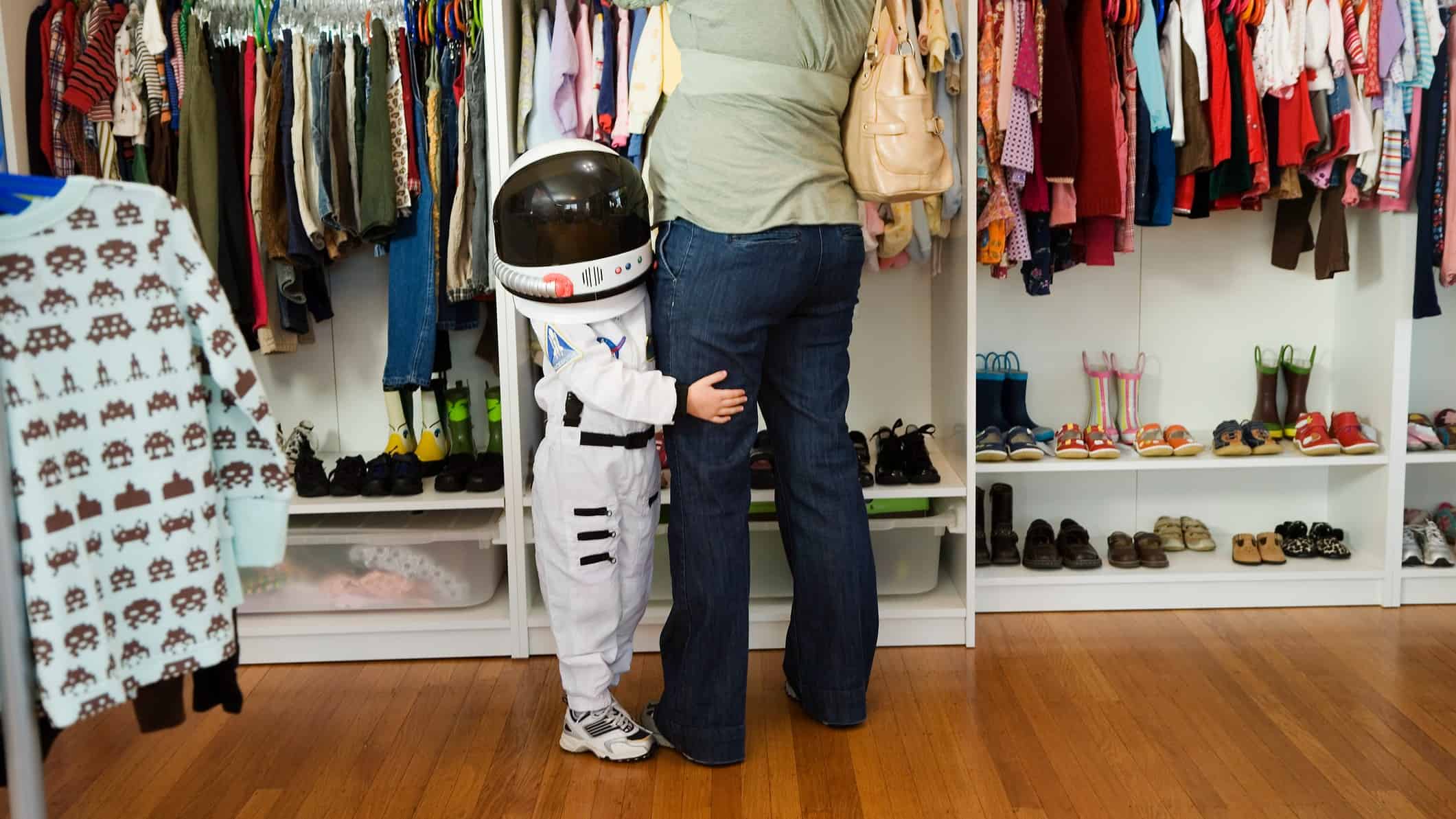 A child wearing an astronaut siut goes shopping with his mother