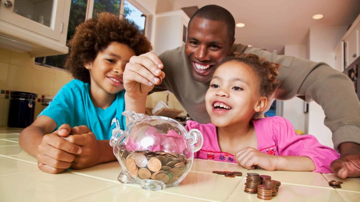 family putting coins into piggy bank