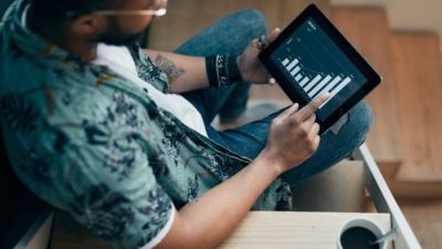 man on an iPad looking at chart of an increasing share price