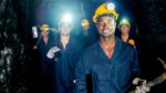 Group of smiling coal miners in a coal mine