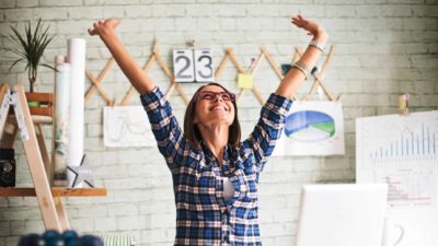 happy woman throws arms in the air