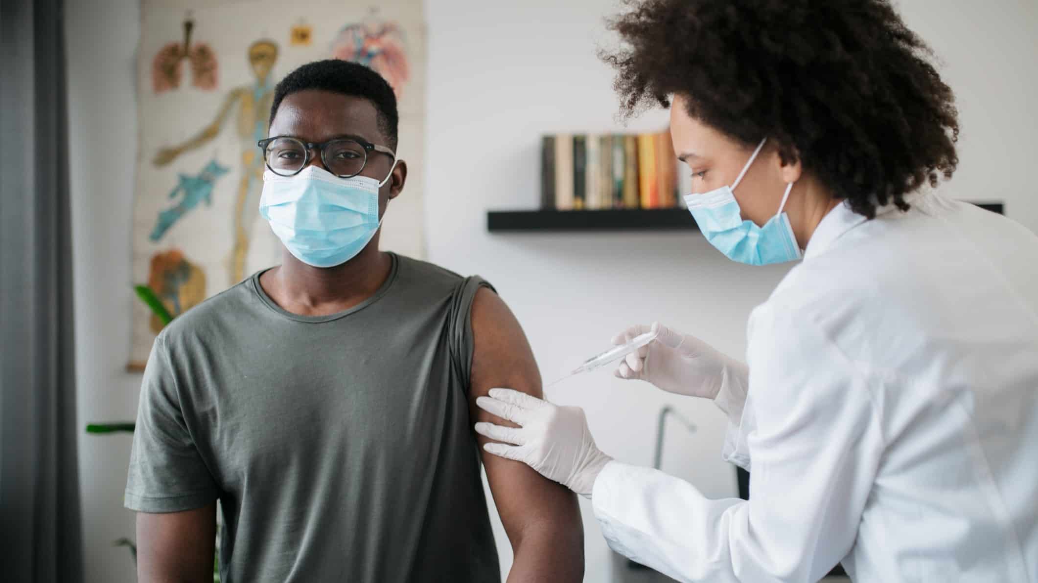 nurse giving a vaccination to a male patient