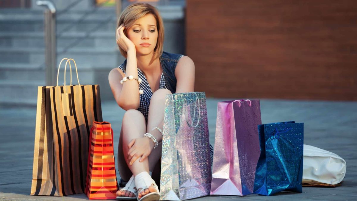 sad woman sitting with shopping bags
