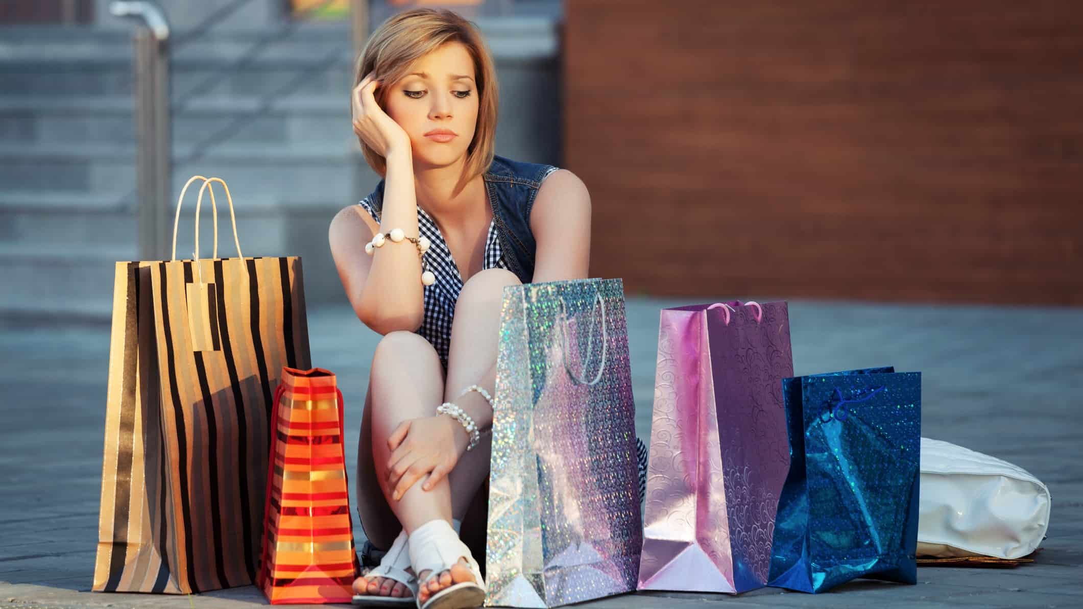 sad woman sitting with shopping bags