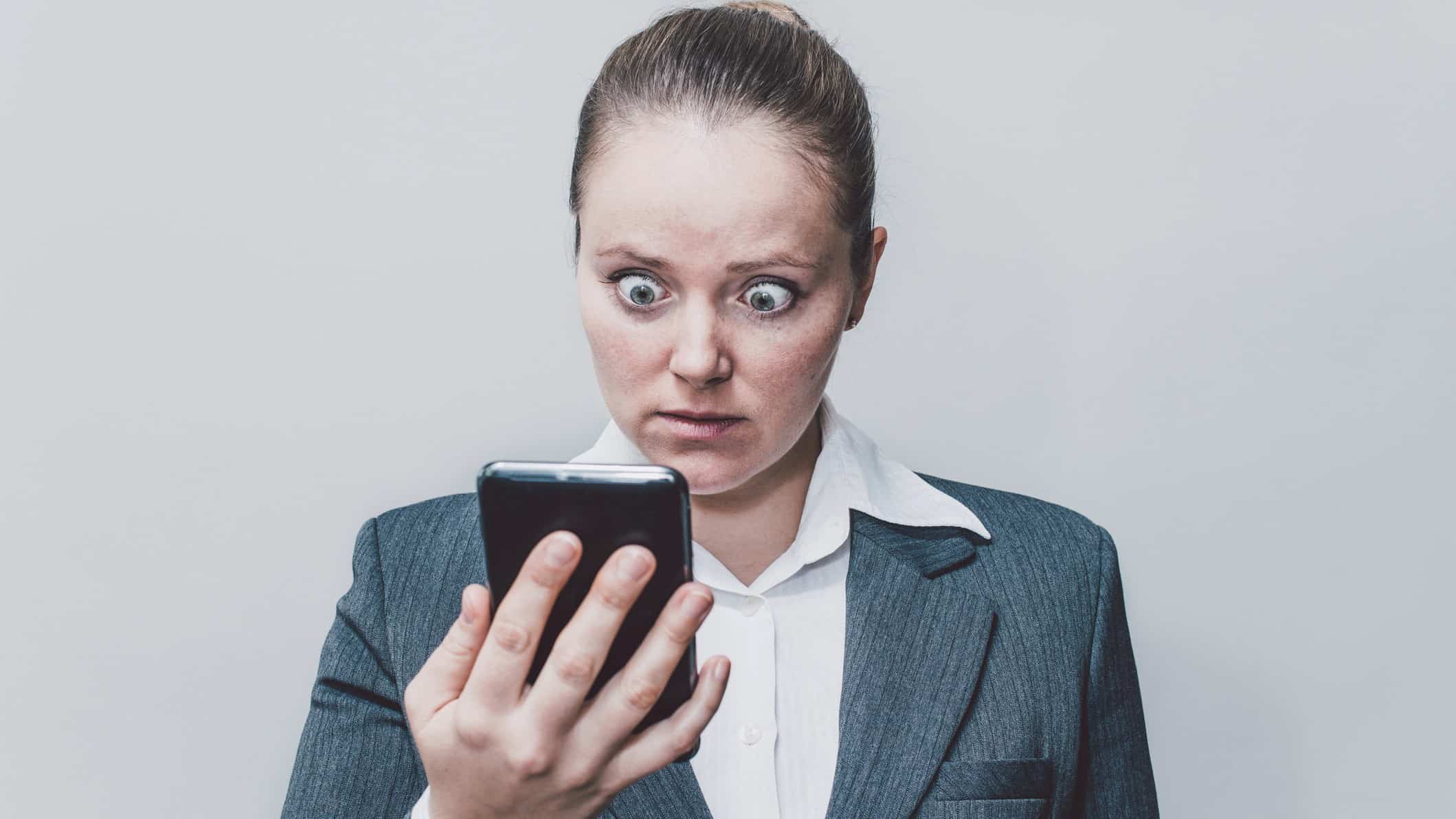 woman looks shocked at mobile phone