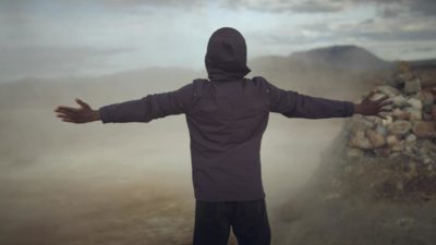 A man faces a mine with arms outstretched.