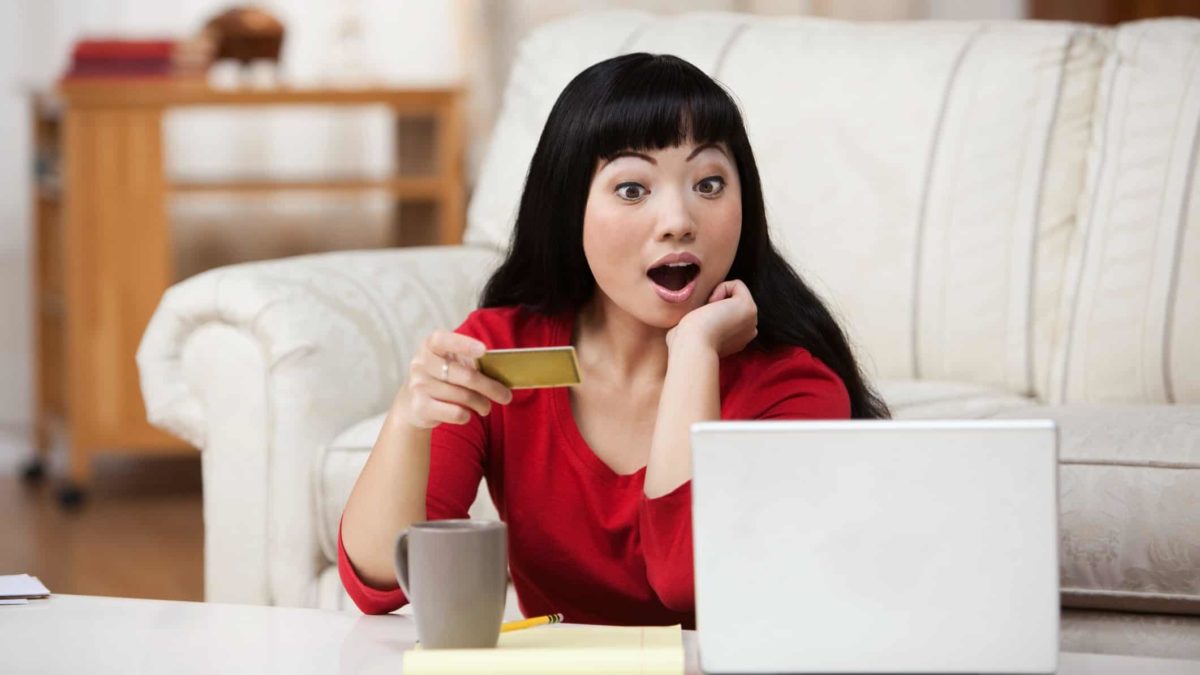 surprised shopper, unexpected news, person at computer with payment card,